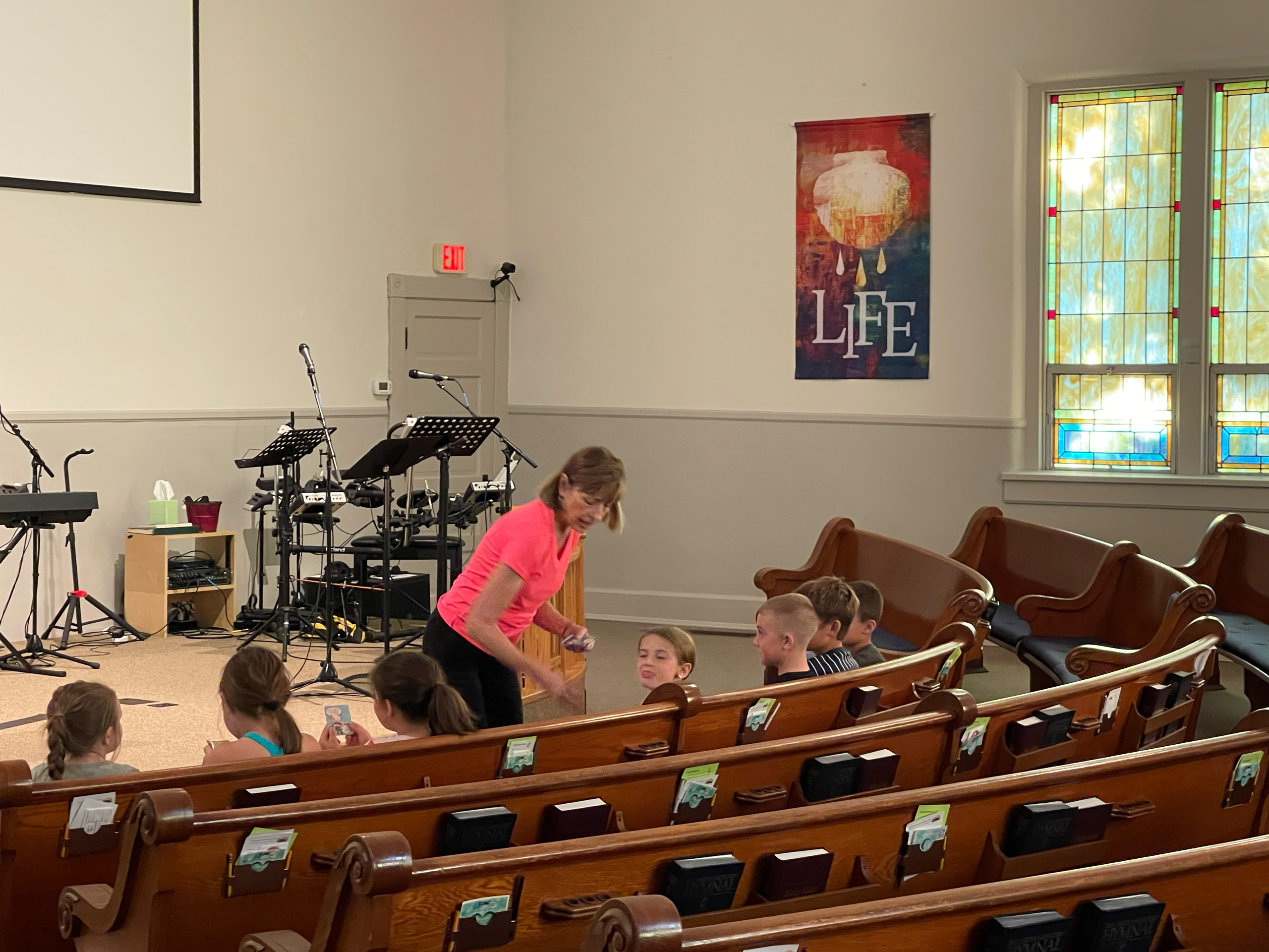 Young children and teacher in pews at Farmersville United Methodist Church