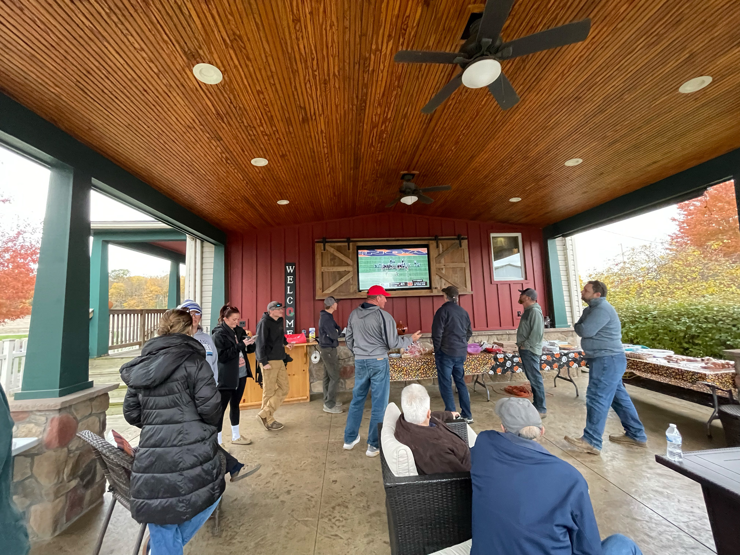 Group of people watching a football game outside on a television